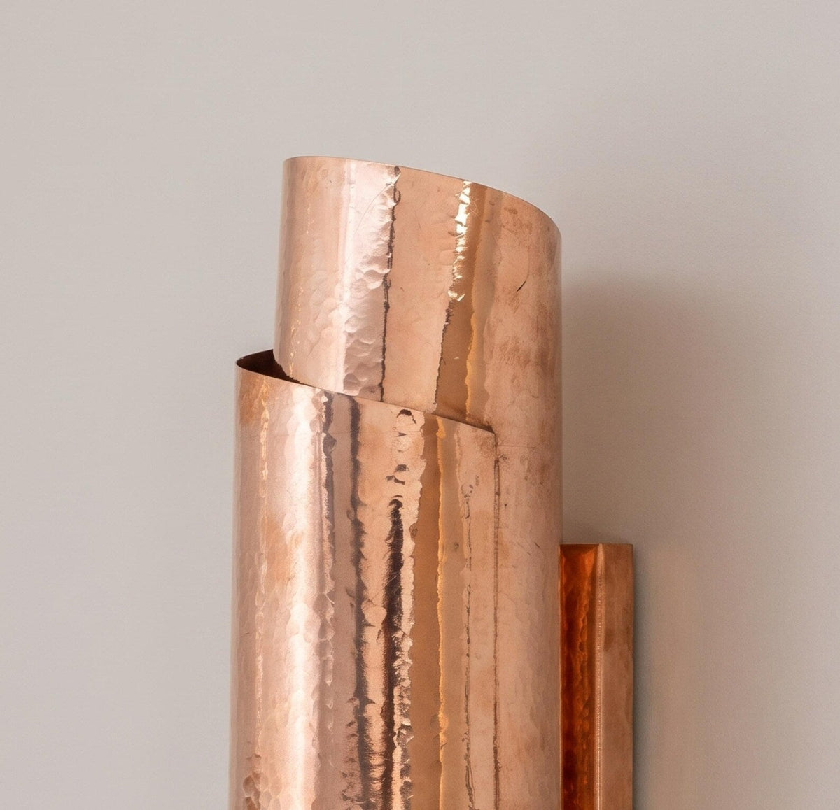 Close-up of the hammered copper surface and overlapping curves