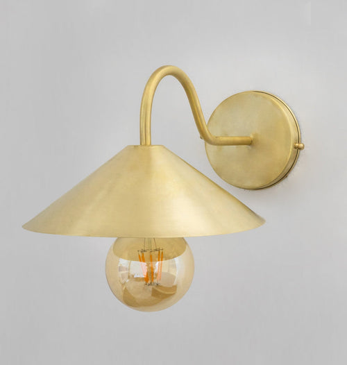 Angled view of the brass gooseneck wall lamp and round backplate