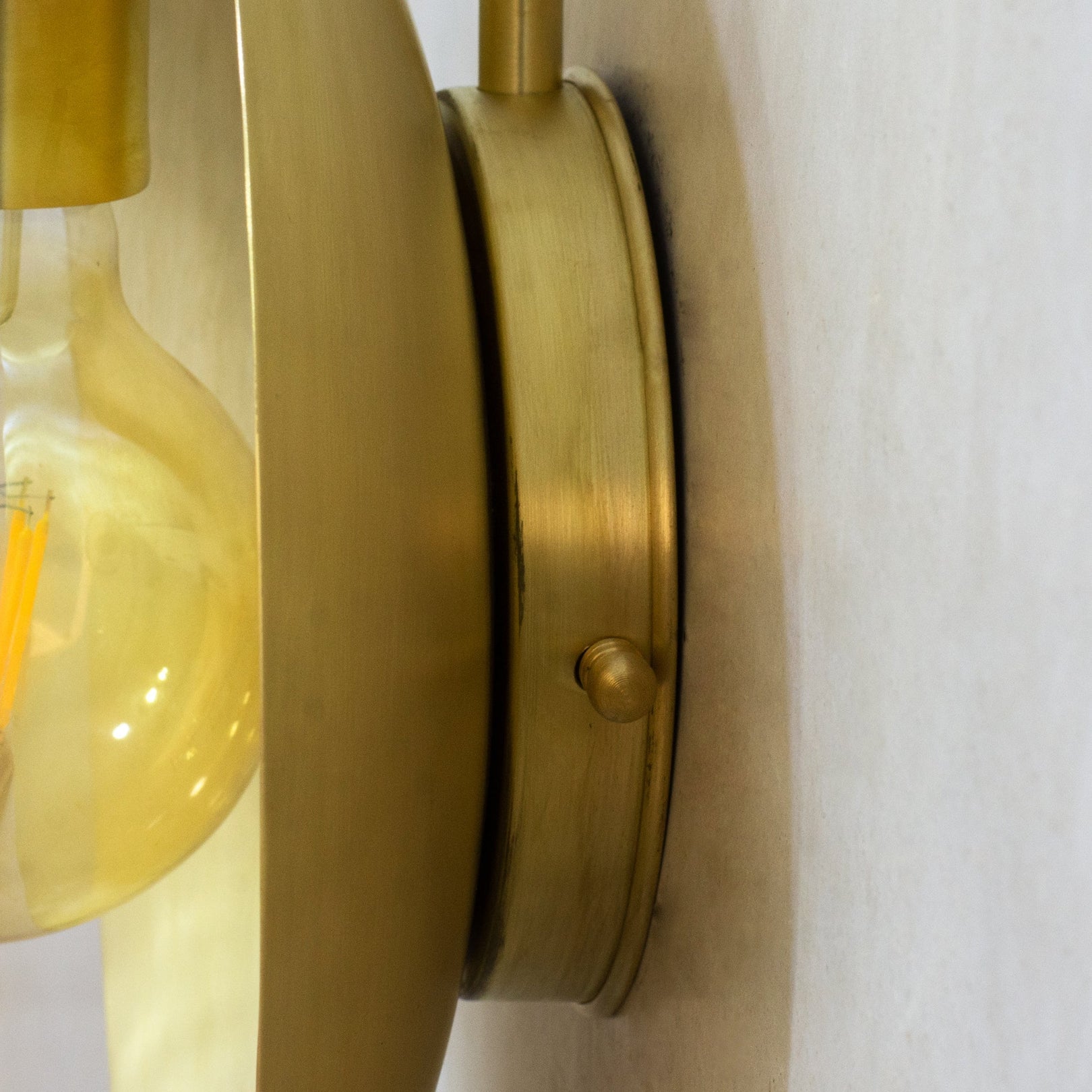 Side view of the brass wall mounting plate and reflector