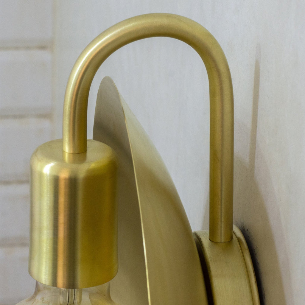 Close-up of the curved brass arm and socket cover