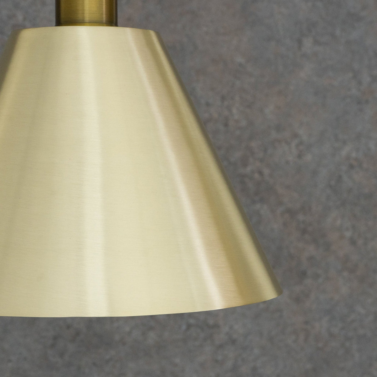 Close-up of the satin brushed brass shade surface and lower edge