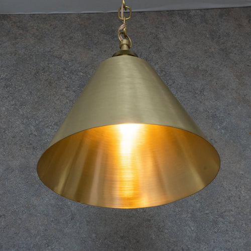 Brushed brass cone pendant showing the warm brass interior and chain suspension