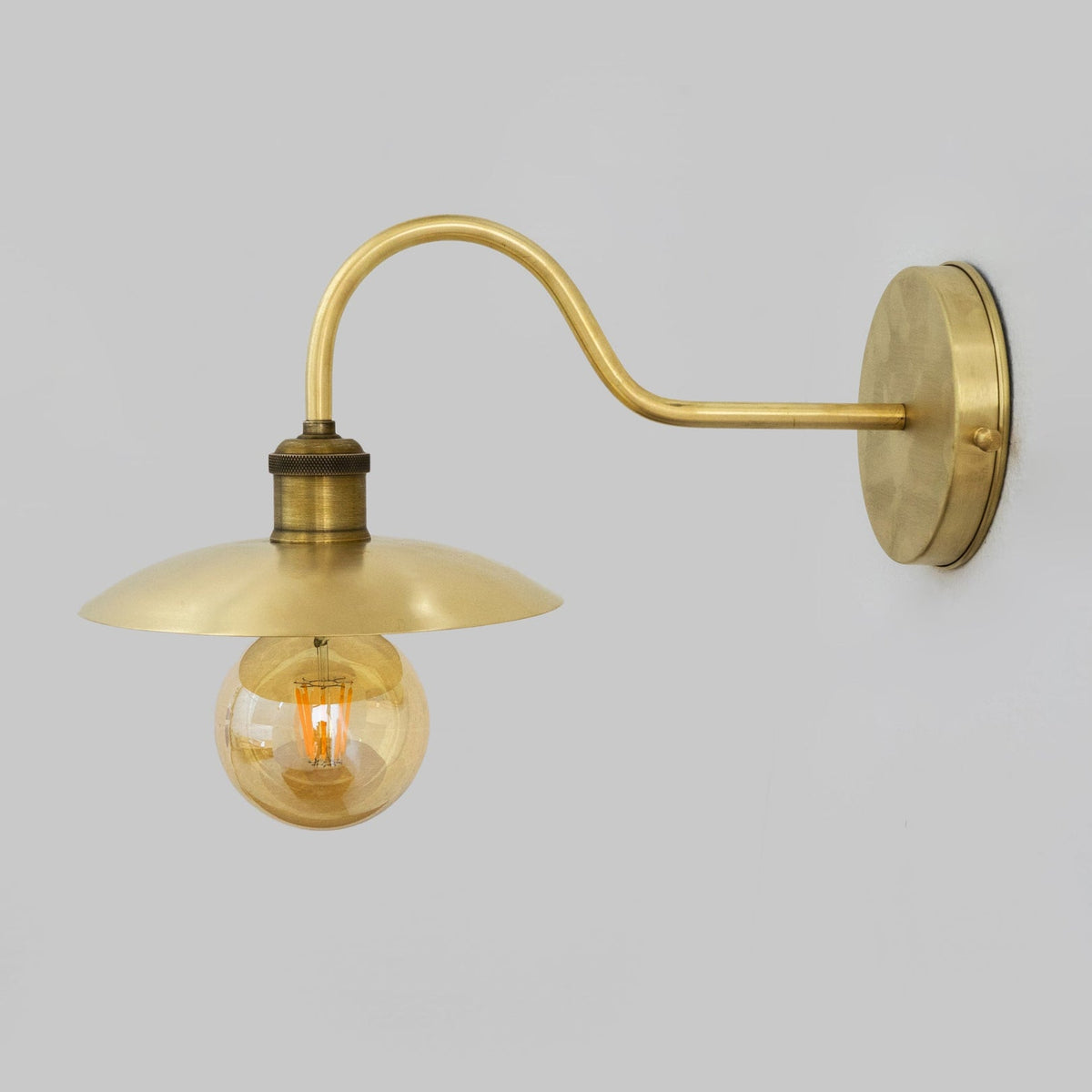 Side profile of the brass wall arm and shallow shade