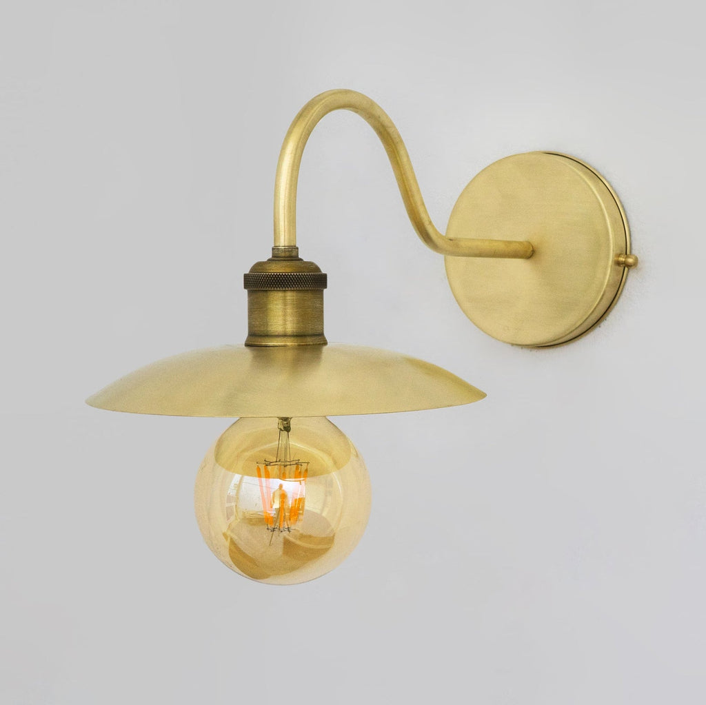 Angled view of the brushed brass shallow-shade wall sconce
