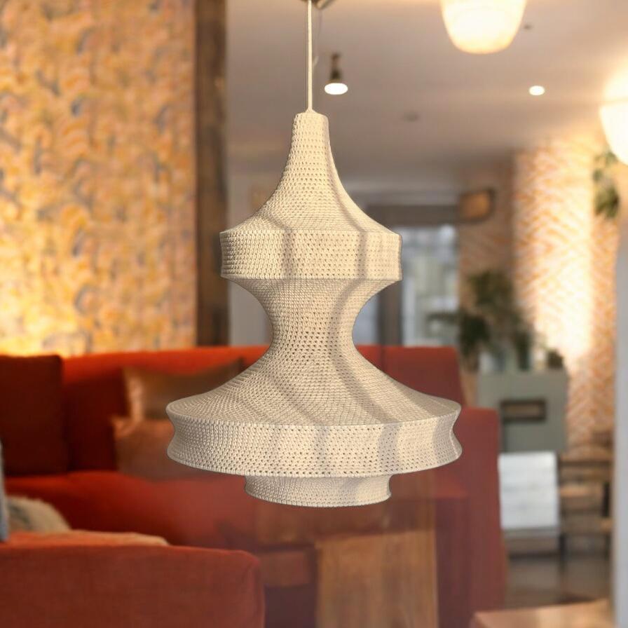 A cream-colored pendant light fixture featuring a textured, crocheted fabric shade with a tiered, hourglass-inspired…