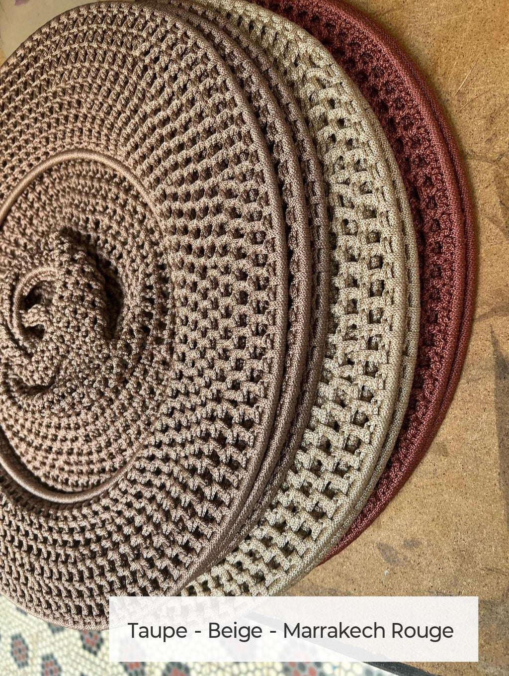A set of three circular, crocheted coasters or placemats stacked together. The items feature a textured, open-weave…