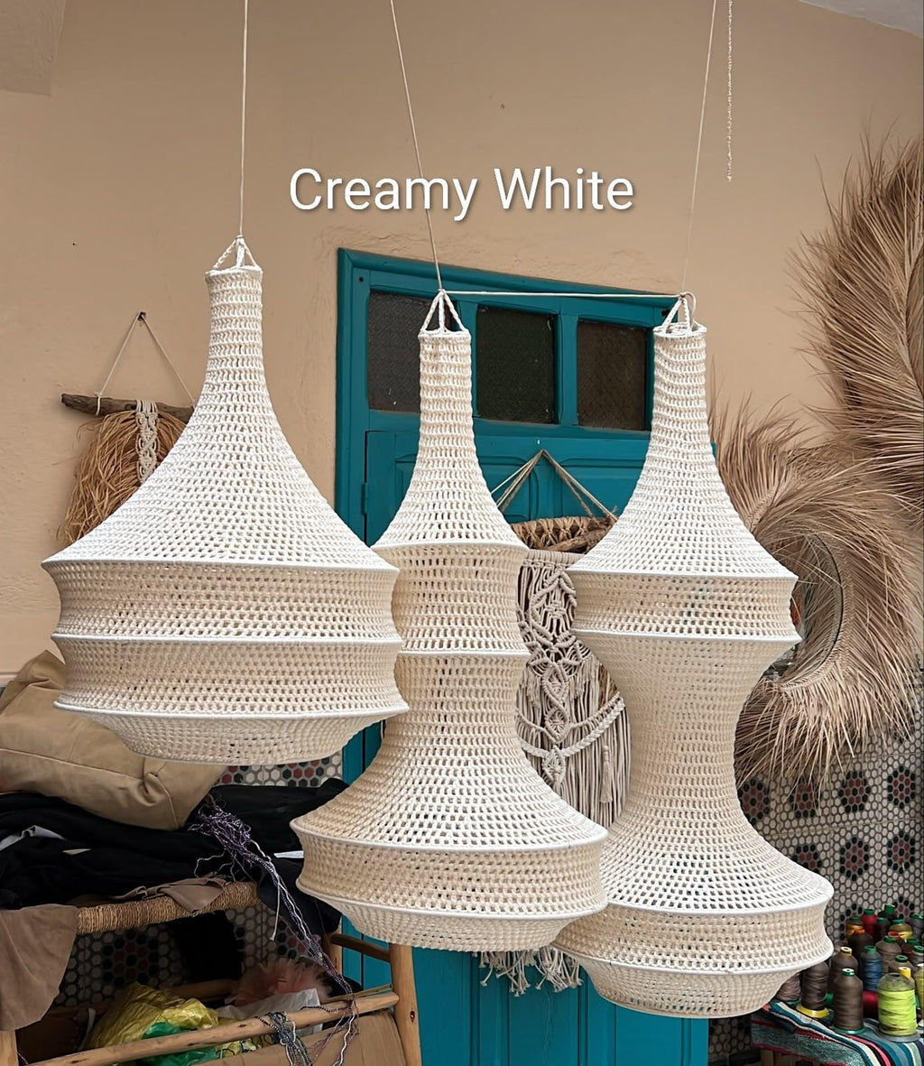Three hanging pendant lamps in a creamy white color, each featuring a distinct crocheted or woven open-work pattern. The…