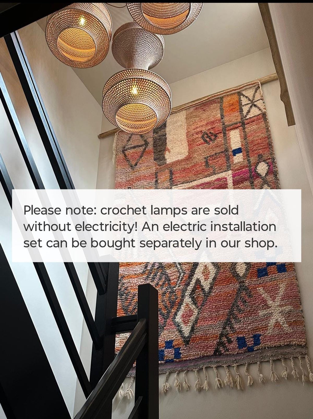 Three woven pendant lamps with a light brown finish hanging above a large, rectangular wall tapestry featuring a…