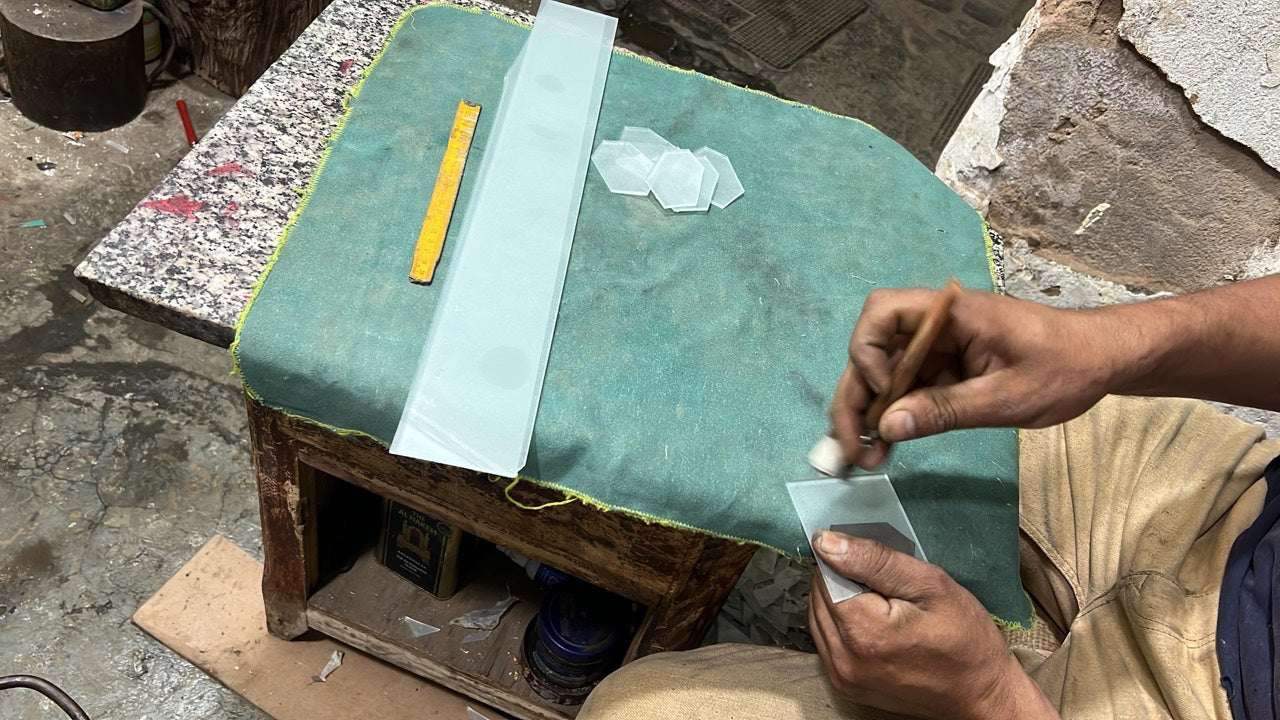 Artisan preparing individual glass pieces at a workbench
