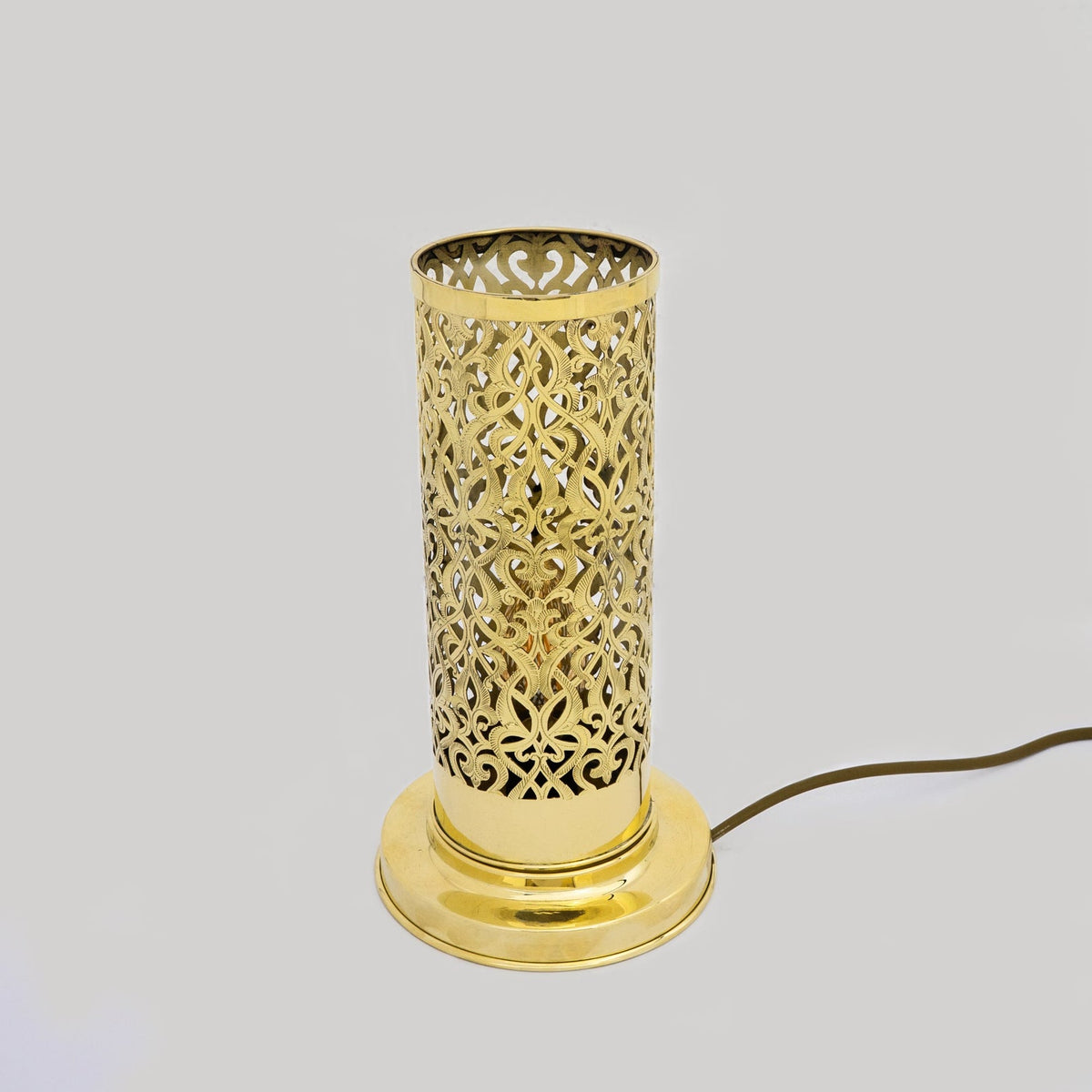 Full view of the pierced brass cylinder table lamp with its circular base